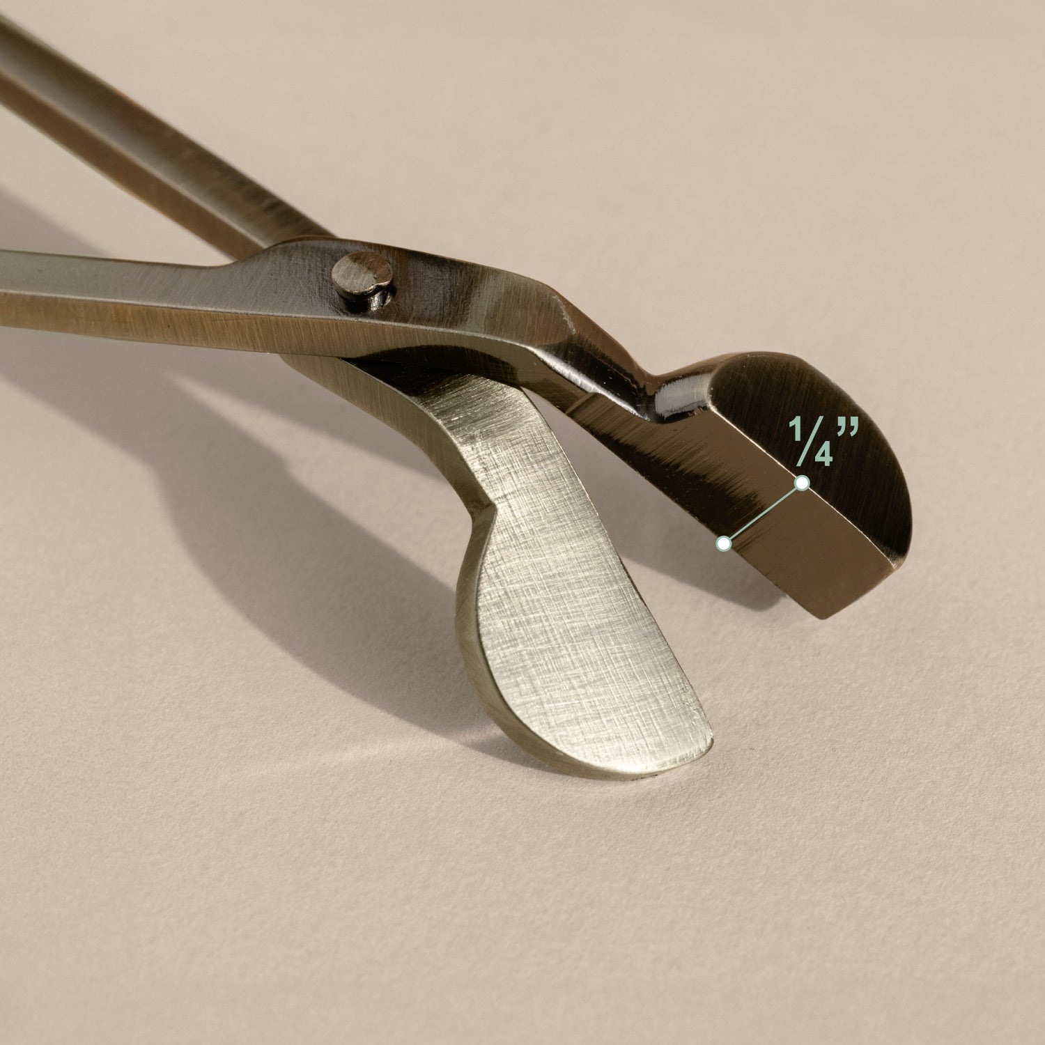 Wick Trimmer with a textured handle on a beige background